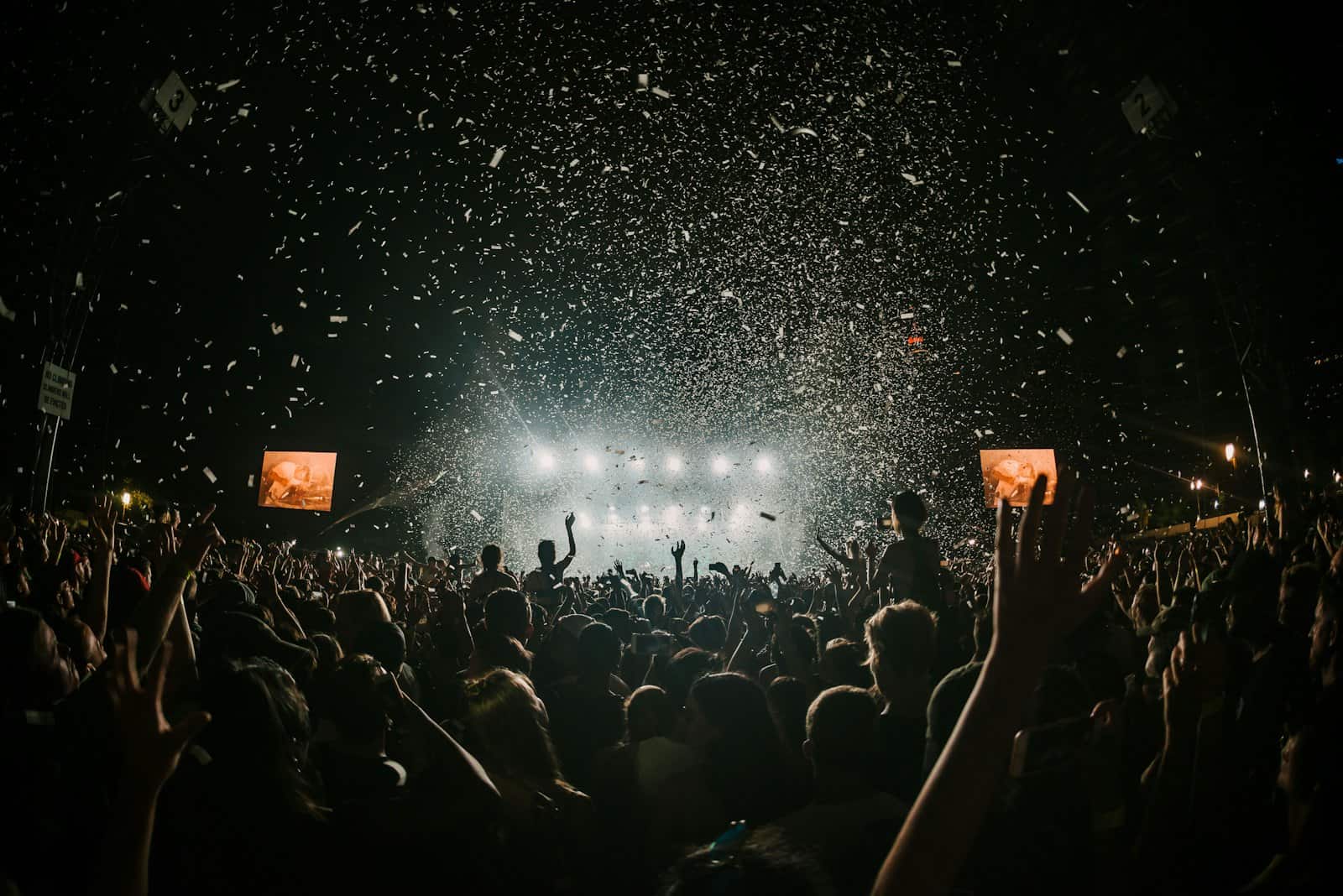 Festival crowd under confetti against the night sky